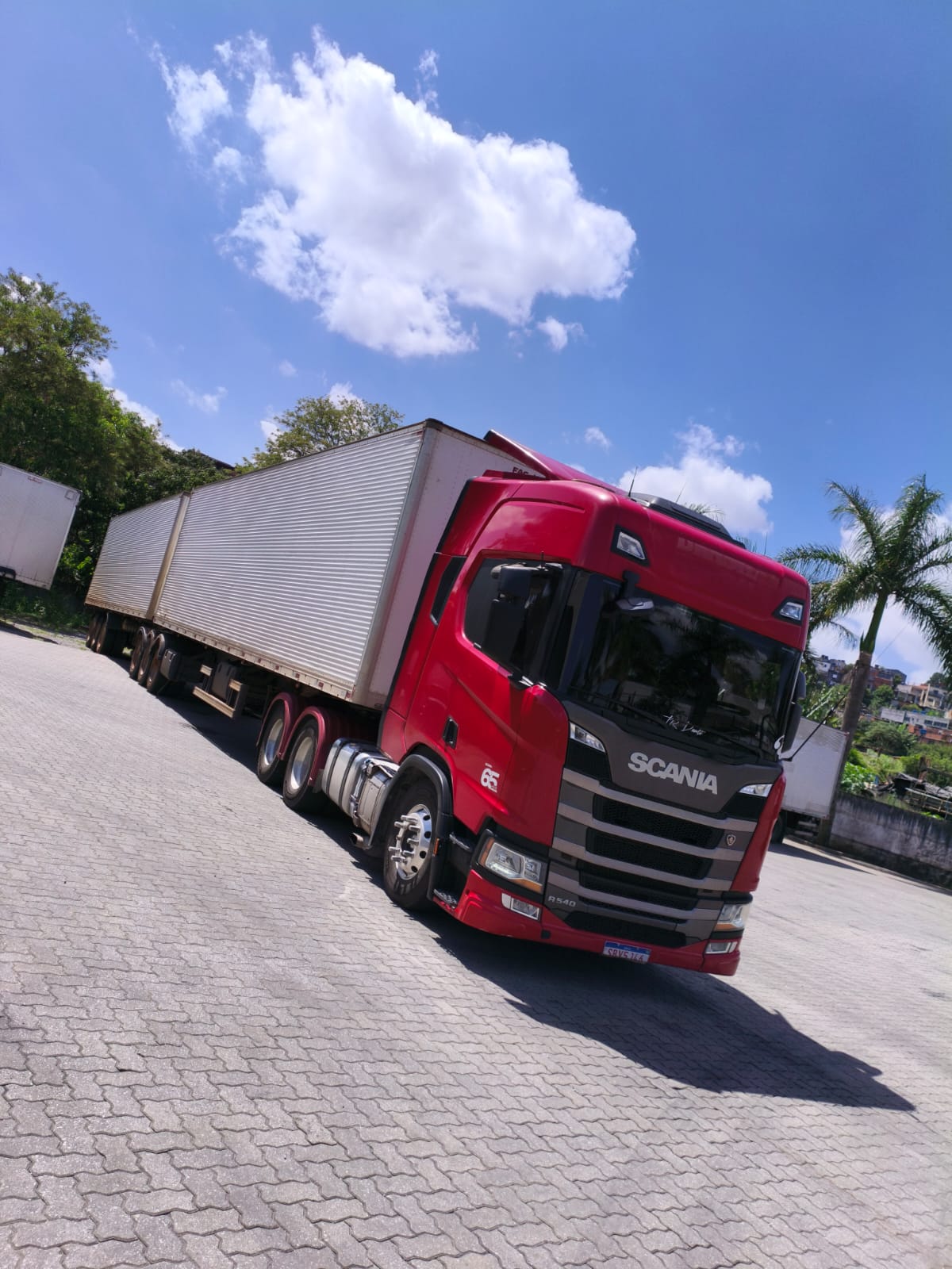 Caminhão verde com carreta baú à noite