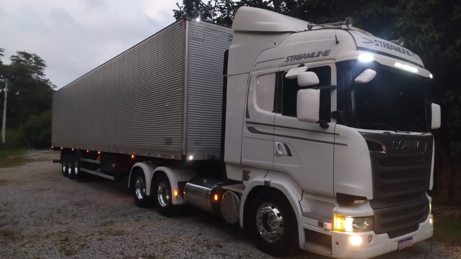 Caminhão branco com baú em baixa luz